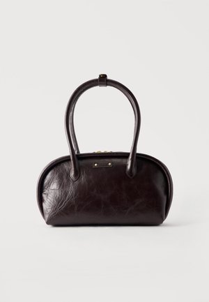 Sac à main en cuir marron foncé de forme arrondie, avec des doubles poignées et une petite plaque logo dorée à l'avant.