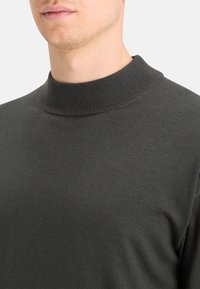 Ciemnoszara dzianinowa sweter z wysokim, ściąganym kołnierzem oraz gładką teksturą, o dopasowanym kroju podkreślającym dekolt i ramiona.