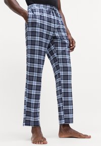 Pamučne hlače za spavanje s kariranim uzorkom u plavim i tamnoplavim tonovima, s elastičnom gumicom u struku i bočnim džepovima. Ravne nogavice.