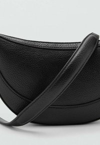 Crna kožna torba preko ramena s teksturom, zakrivljenog oblika i širokim remenom, postavljena na svijetlu jednobojnu pozadinu.