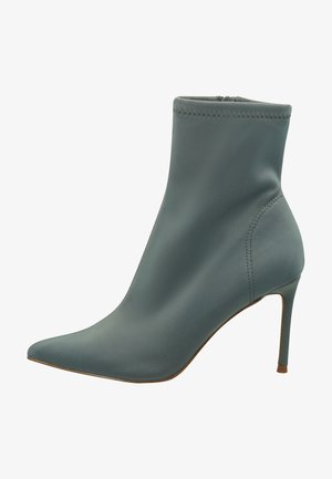 Spitz zulaufender Knöchelschuh aus glattem, schlichten Teal-Leder mit einem Stiletto-Absatz. Merkmale sind dezente Nähte und ein figurschmeichelndes, elegantes Design.