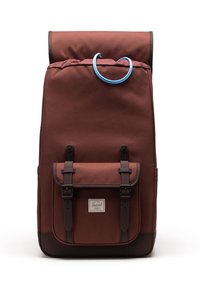 Zaino in tessuto marrone con tasca frontale, due cinturini scuri con fibbia, pattina superiore e manico blu su sfondo bianco.