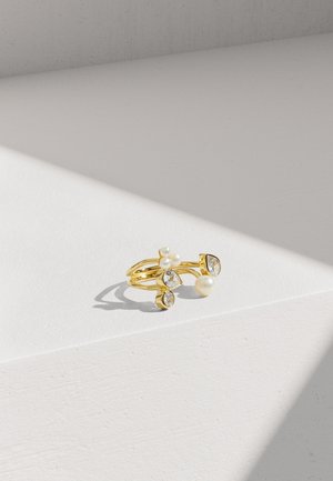 Zlatni prsten s višestrukim nitima, ukrašen biserima i prozirnim dragim kamenjem u oblicima suze i kruga, s glatkom refleksivnom završnom obradom.