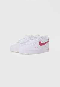 Valkoiset Nike Air Force 1 -tennarit, joissa on vaaleanpunaiset yksityiskohdat. Tässä mallissa on sileä nahkapinta, pyöreä terävä, nauhat ja teksturoitu kumipohja.
