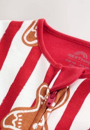Tutina per neonato a righe rosse e bianche con motivo di omini di pan di zenzero, chiusura con cerniera e tessuto morbido in cotone. Bordo rosso distintivo sul collo.