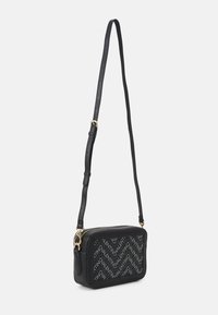 Borsa a tracolla in pelle nera con chiusura a zip, caratterizzata da un motivo logo ripetuto sulla parte frontale e una cintura sottile regolabile. Accenti in hardware dorato.