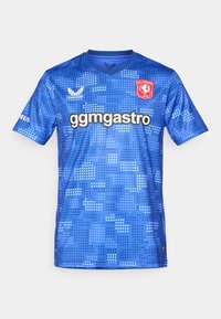 Modrý fotbalový dres s výstřihem do V, zdobený pixelovým vzorem, s logem na levém prsu a nápisem "ggmgastro" na přední straně.