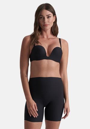 Zwart plunge bh met soepele cups en dunne verstelbare bandjes, gecombineerd met hoge zwarte naadloze shorts, beide gemaakt van rekbaar materiaal.