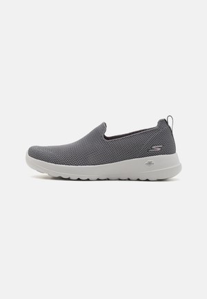 Grå slip-on-sneaker med meshtopp, vit gummisula och subtil logodetalj. Har rundad tå och elastiska sidoinlägg för flexibilitet.