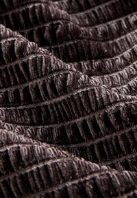 Csokoládébarna textúrált szövet függőleges bordázott mintázattal. Puha, bolyhos felülettel, amelynek enyhe fényessége van, alkalmas kárpitozásra vagy divat alkalmazásokhoz.