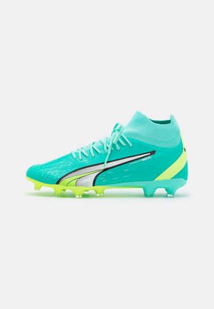 Türkise Fußballschuhe mit einem sockenartigen Kragen, grünen Akzenten und einer strukturierten Oberfläche. Verfügt über schwarze Markierungen und transparente Noppen.