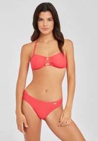 Rotes geripptes Bikini-Set mit einem Bandeau-Top und einem Ausschnitt auf der Vorderseite sowie verstellbaren Trägern, kombiniert mit passenden, niedrig geschnittenen Bikini-Höschen.