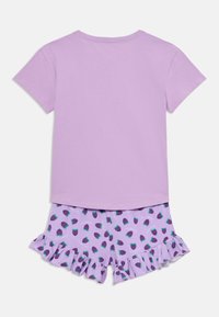 T-shirt lilas à manches courtes assorti à un short avec imprimé ananas et ourlet volants. Matière en coton doux avec une coupe confortable.