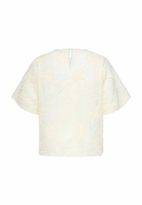 Blouse ivoire à manches courtes avec broderie florale et petite fermeture à boutons au dos de l'encolure, présentée sur fond blanc uni.