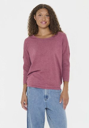Lichte, getextureerde pullover in mauve, met een ronde hals en driekwart mouwen, gecombineerd met blauwe denim jeans.
