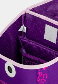 Borsa da stoccaggio viola con bordo rosa, tasche interne con un motivo triangolare e un'etichetta per l'organizzazione. Tessuto testurizzato.