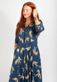 Blaues Kleid mit Knopfleiste vorne. Hat ein Tiger-Muster und Dreiviertelärmel. Hergestellt aus leichtem Stoff mit einem fließenden Design.
