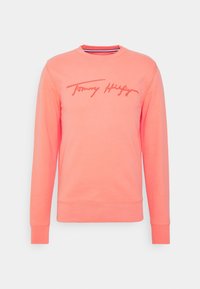 Korale sweter uszyty z miękkiego materiału, z okrągłym dekoltem i długimi rękawami. Logo "Tommy Hilfiger" w kontrastowym czerwonym przeszyciu.