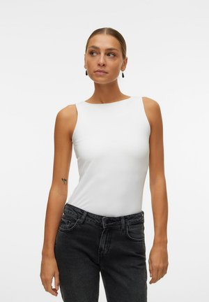 Body bianco senza maniche realizzato in tessuto morbido, con scollatura rotonda e silhouette aderente, abbinato a jeans in denim scuro.