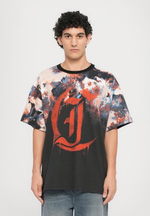 Schwarzes T-Shirt mit buntem abstraktem Design in Rot, Blau und Orange. Mit einem markanten roten Buchstaben "J"-Grafik. Kurze Ärmel, lockere Passform.