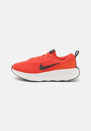 Chaussure de running Nike orange vif avec logo Swoosh noir, semelle blanche épaisse et languette noire au talon.