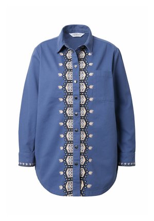 Blauwe shirt met lange mouwen, knoopsluiting aan de voorkant en geborduurd geometrisch patroon in het midden. Heeft een borstzak en een zachte stoftextuur.