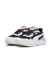 Sneaker Puma con tomaia in mesh nera, dettagli in pelle bianca, accenti viola e rosa, e suola testurizzata per una buona aderenza.