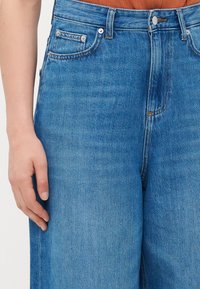 Blå høyt midje jeans med avslappet passform, med fem lommer, metallknapplukking og subtil falming i denimstrukturen.