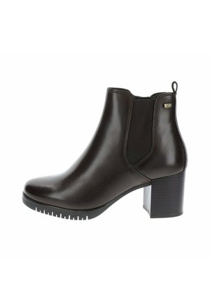 Bota de piel marrón oscuro con tacón bloque, panel lateral elástico y lengüeta para tirar, vista desde el lateral exterior sobre fondo blanco.