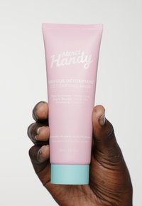 Rosa tub med Merci Handy detoxmask med turkos lock. Innehåller Damaskusros, vit lera och vitamin C. Etiketten har text på franska och engelska.