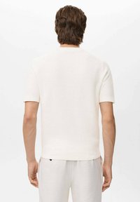 Witte shirt met korte mouwen van een gestructureerde stof en ribbelaccenten bij de mouwen en de zoom. Eenvoudig ontwerp, aangesloten snit en een nette afwerking.