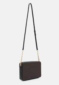 Sort crossbody taske med kæde og justerbar rem. Har et monogrammønster på brun stof og glatte sorte læderdetaljer.