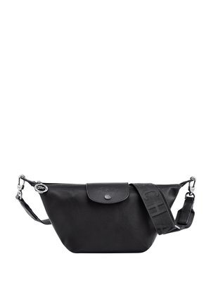 Black leather bag with a curved shape, top zipper closure, and adjustable strap featuring embossed logo patterns. Subtle branding on flap.