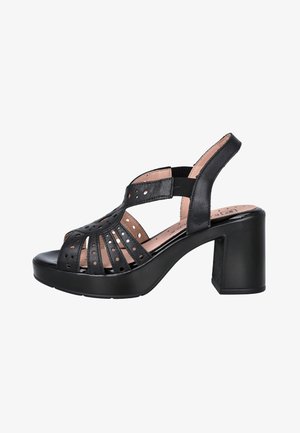 Sandalia de cuero negro con diseño perforado, puntera abierta, tira trasera y tacón grueso tipo bloque.