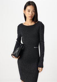 Mustmustriban mustkleit pikka varrukatega, ümmarguse kaeluse ja kitsaste joontega. Omab peent sära ja väikest logo küljel.