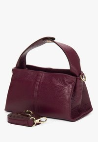 Bordowa skórzana torebka o teksturowanej powierzchni, wyposażona w krótką rączkę i odpinany pasek na ramię, z dodatkami w kolorze złotym.