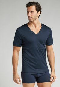 Granatowa koszulka T-shirt z dekoltem w serek, wykonana z gładkiego materiału, krótkie rękawy i luźny krój, w połączeniu z dopasowanymi bokserkami w podobnym materiale i kolorze.