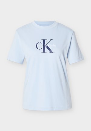 Világoskék pamut póló rövid ujjakkal. Feltűnő tengerészkék "CK" logóval és fehér "Calvin Klein" felirattal. Klasszikus környakú kivitel.