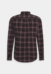 Camicia da uomo a maniche lunghe con un motivo a quadri in nero, rosso e grigio. Presenta un colletto a camicia e polsini con un solo bottone. Tessuto testurizzato.