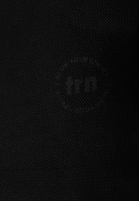 Czarna, teksturowana tkanina z subtelnym wytłoczonym logotypem, prezentująca siatkowy wzór z drobnymi, uniesionymi detalami.