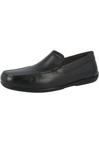 Mocassin pour homme en cuir noir à enfiler, avec des détails cousus et un bout légèrement arrondi sur un fond blanc.