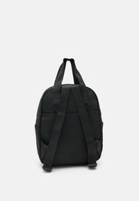 Mustast kanvasest seljakott, millel on kaks reguleeritavat õlarihma, ülemine käepide ja küljetaskud täiendavaks ladustamiseks. Sile tekstuur.