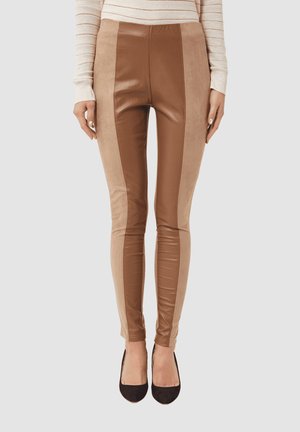 Leggings marrones de cuero sintético y ante con una textura suave, que presentan paneles contrastantes y un diseño ajustado.