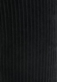 Svart kordfluer tyg med vertikal ribbad textur, som har fina ränder och ett mjukt utseende, lämpligt för olika klädesplagg.