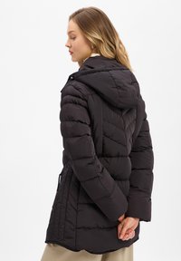 Czarna kurtka puchowa z kapturem, z pikowanym wzorem, bocznymi kieszeniami oraz regulowanym pasem z troczkami. Gładka, błyszcząca tekstura.