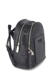 Sac à dos en cuir noir avec le texte en relief "JE SUIS RESPONSABLE", fermetures éclair dorées à double sens, poche latérale et bretelles ajustables. Forme arrondie.