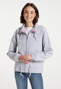 Šedá mikina na zip s vysokým límcem, růžovými akcenty, šňůrkami a malým srdíčkovým logem na hrudi. Měkká, útulná tkanina.