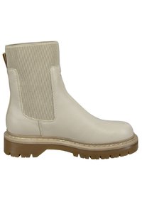 Beige läderankelboot med ribbad elastisk sidopanel, rund tå och en texturerad gummisula. Har en kontrasterande ljusbrun sula.