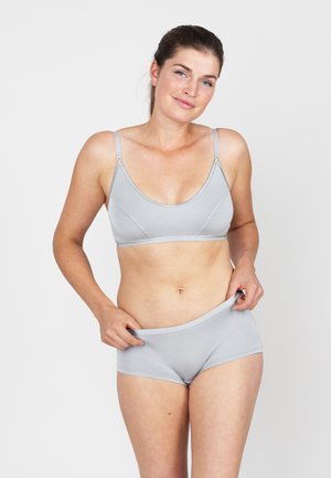 Lichtgrijze naadloze bralette met verstelbare banden en een bijpassende low-rise slip, gemaakt van zachte, rekbare stof.