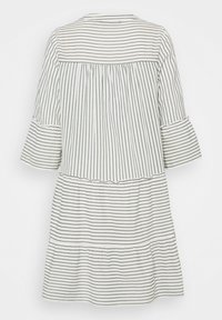 Robe blanche à fines rayures verticales noires, manches cloche trois-quarts, taille froncée et jupe à volants, vue de dos.